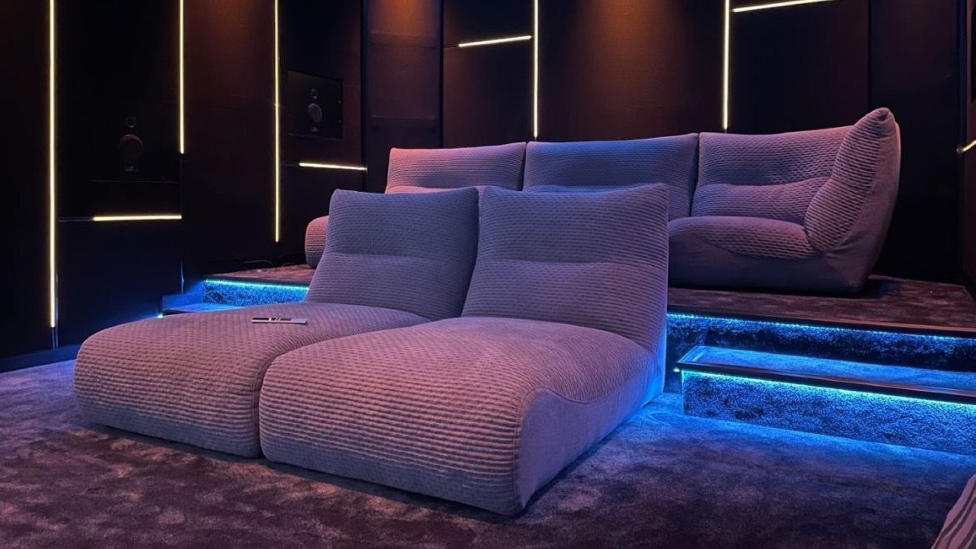 A private screening room with plush lounge seating and ambient lighting